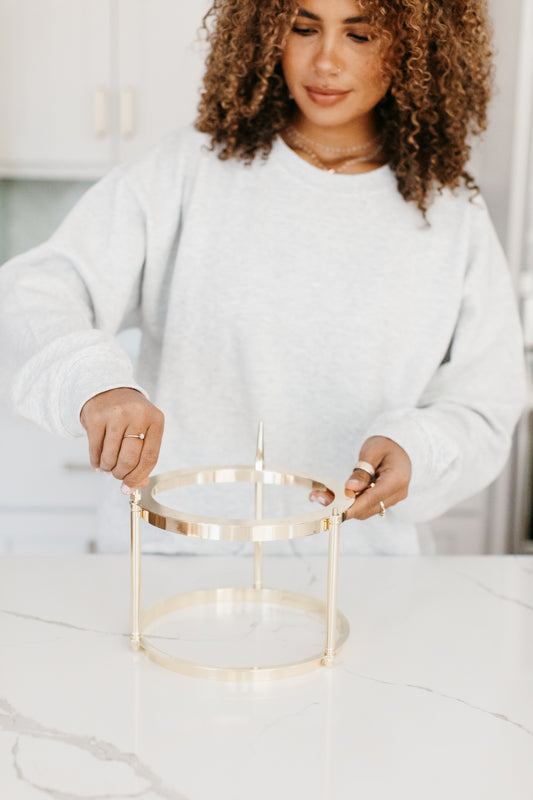 Model posing with an empty luxury candle vessel in hand.