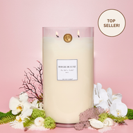 Sea Salt & Orchid Big Ass Candle surrounded by florals to represent the notes of the fragrance.