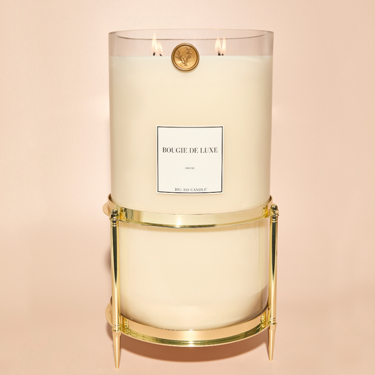 Large unscented luxury candle burning brightly in an elegant holder.