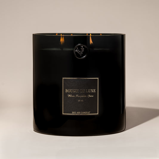 Black Warm Pumpkin Spice candle with a label on a beige background
