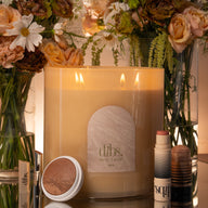 Candle with 'dibs' branding surrounded by flowers