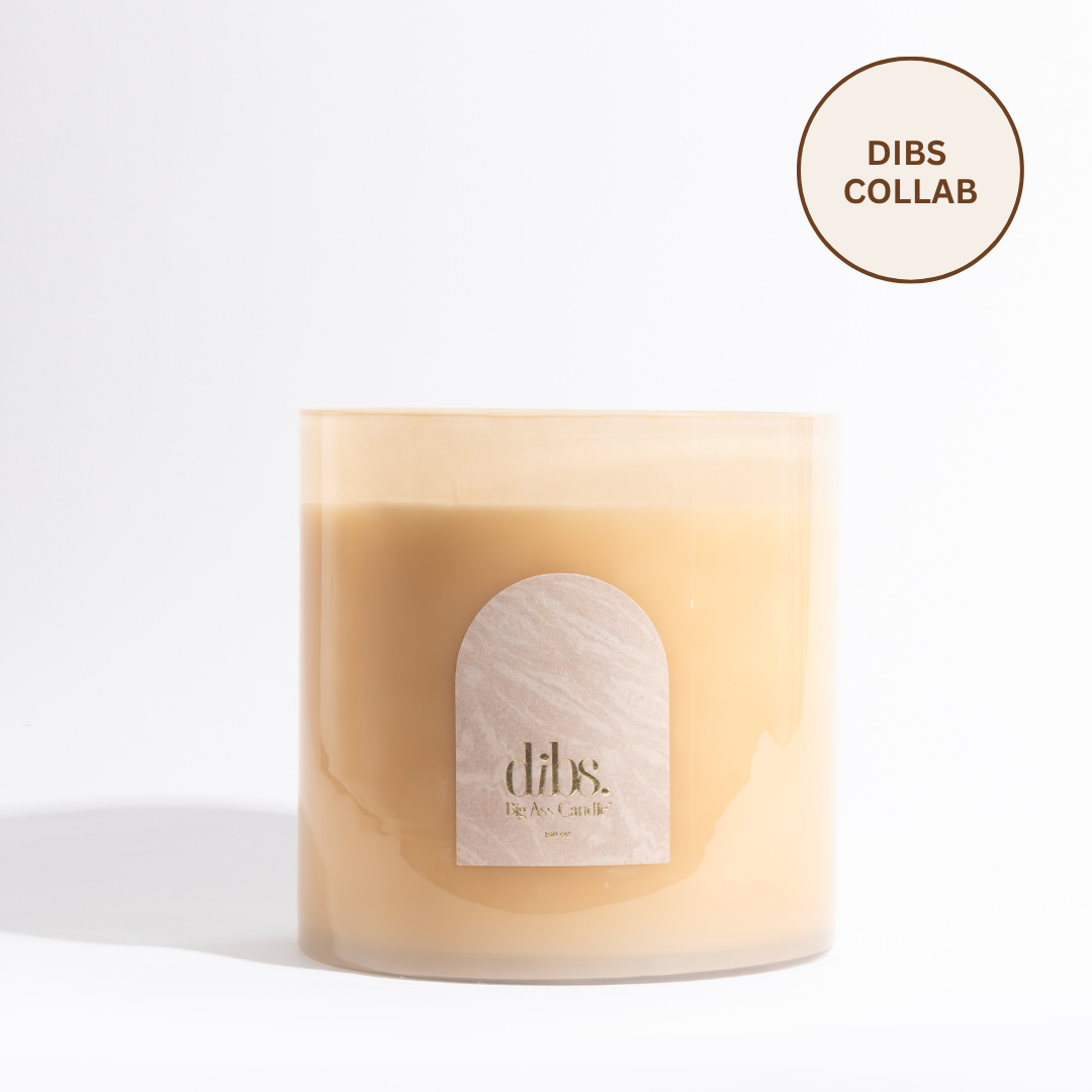 Beige candle with a label on a white background, featuring the 'dibs' brand.
