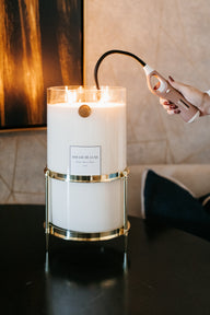 Person lighting a Big Ass Candle in gold holder