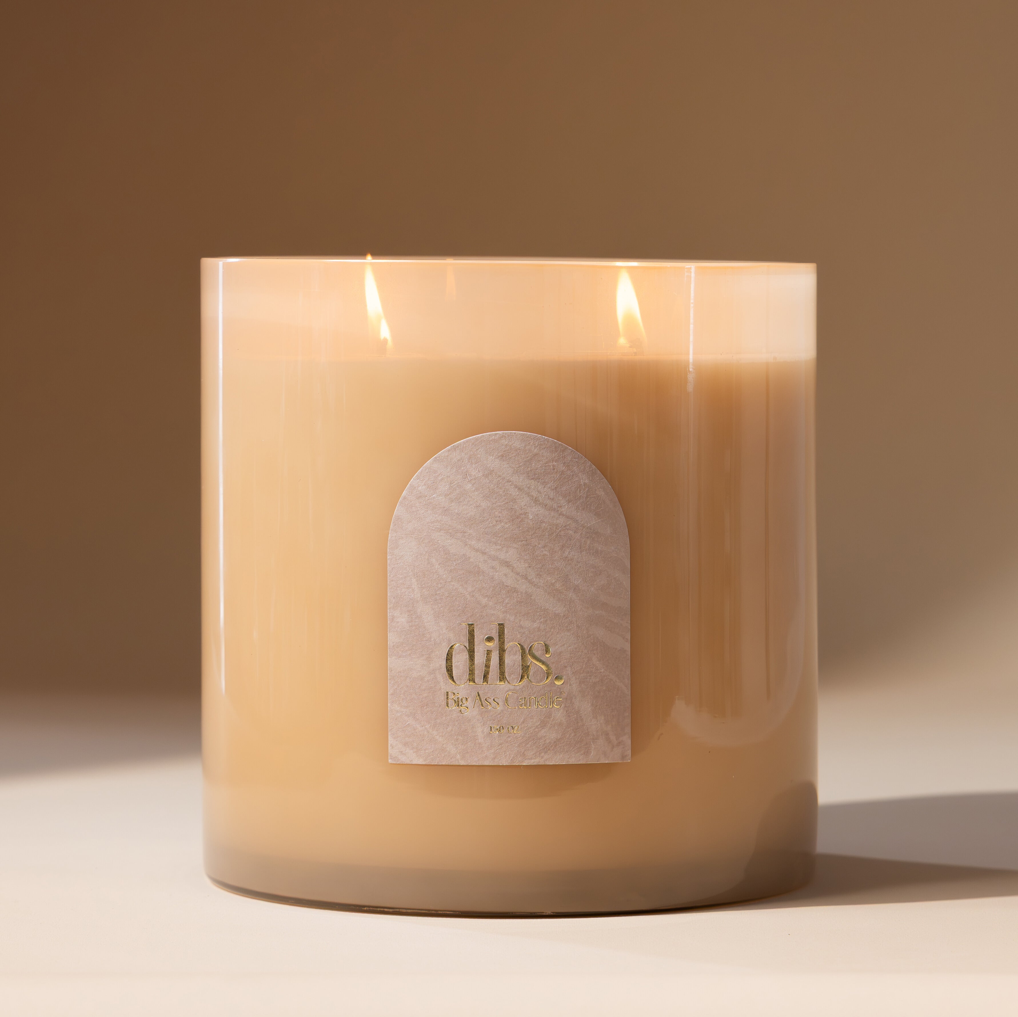 Candle with a 'dibs' label on a beige background
