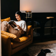 Model reading a book with candle lit