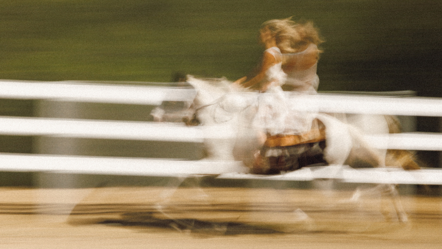 Person riding a horse on a dirt path with blurred motion effect